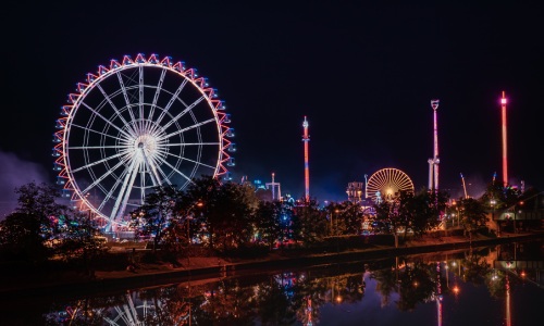 Vergnügungspark mit Riesenrad – beleuchtet in der Nacht
